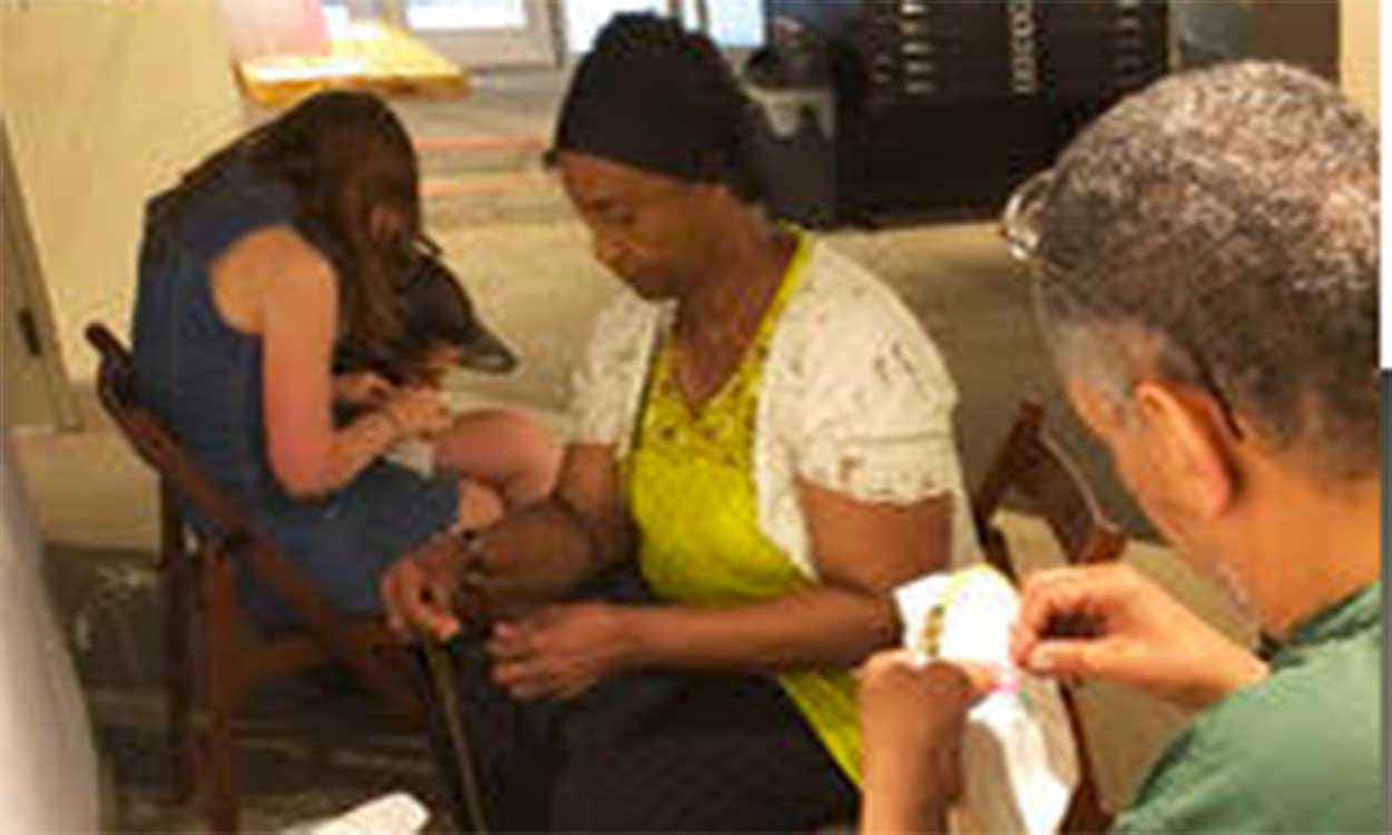 Photo of adult men and women embroidering